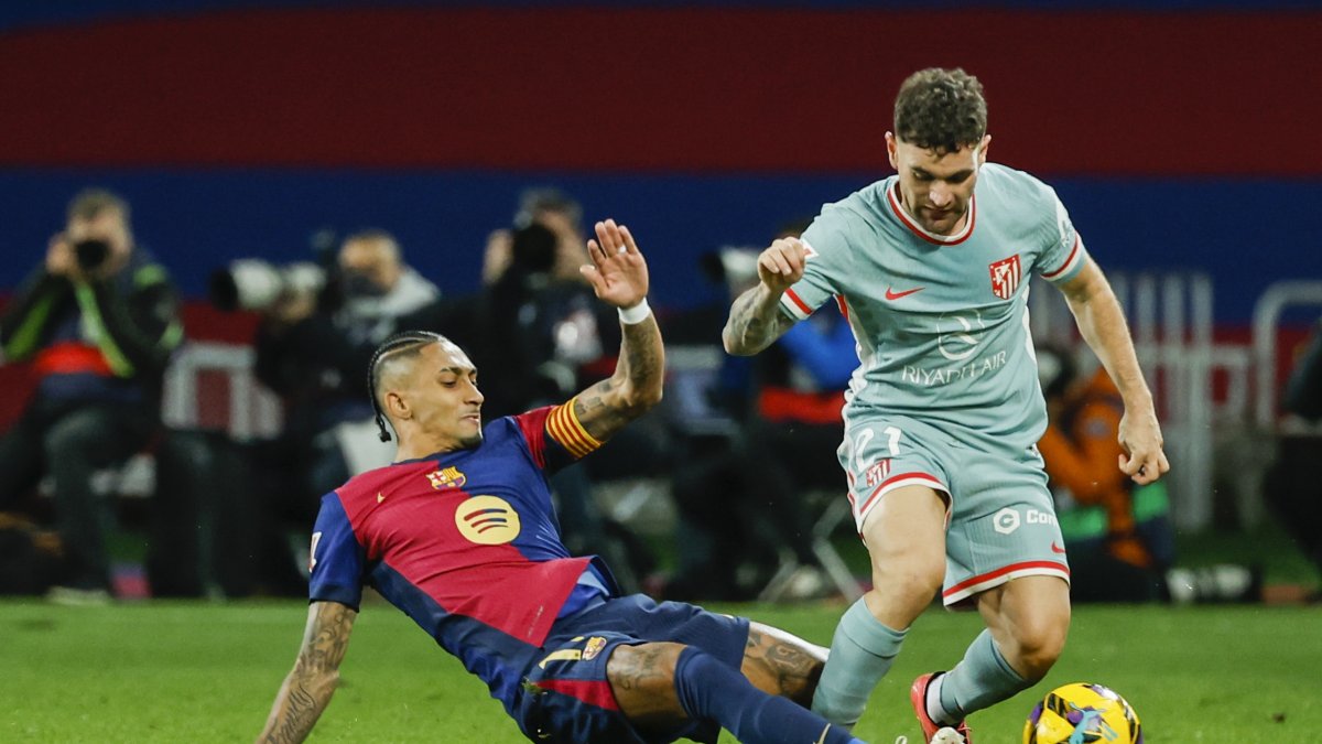 Barcelona's Raphinha (L) duels for the ball with Atletico Madrid's Javi Galan during the Spanish La Liga match at the Lluis Companys Olympic Stadium, Barcelona, Spain, Dec. 21, 2024. (AP Photo)