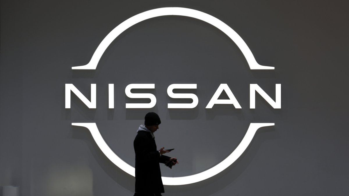 A man walks past the Nissan Motor logo at the carmaker headquarters in Yokohama, near Tokyo, Japan, Feb. 13, 2025. 