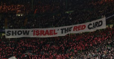 A Palestine flag is seen as Celtic fans display a banner stating &#039;Show Israel the red card&#039; during the Champions League knockout phase playoff first leg match against Bayern Munich at the Celtic Park, Glasgow, Scotland, U.K., Feb. 12, 2025. (Reuters Photo)