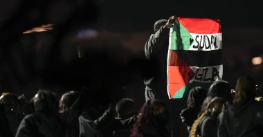 An attendee holds flags during halftime of the NFL Super Bowl 59 football game between the Kansas City Chiefs and the Philadelphia Eagles, New Orleans, U.S., Feb. 9, 2025. (AP Photo)