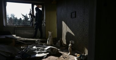 A police officer observes an area for enemy drones from an apartment building damaged by Russian military strikes, in Orikhiv, Zaporizhzhia region, Ukraine, Feb. 12, 2025. (Reuters Photo)