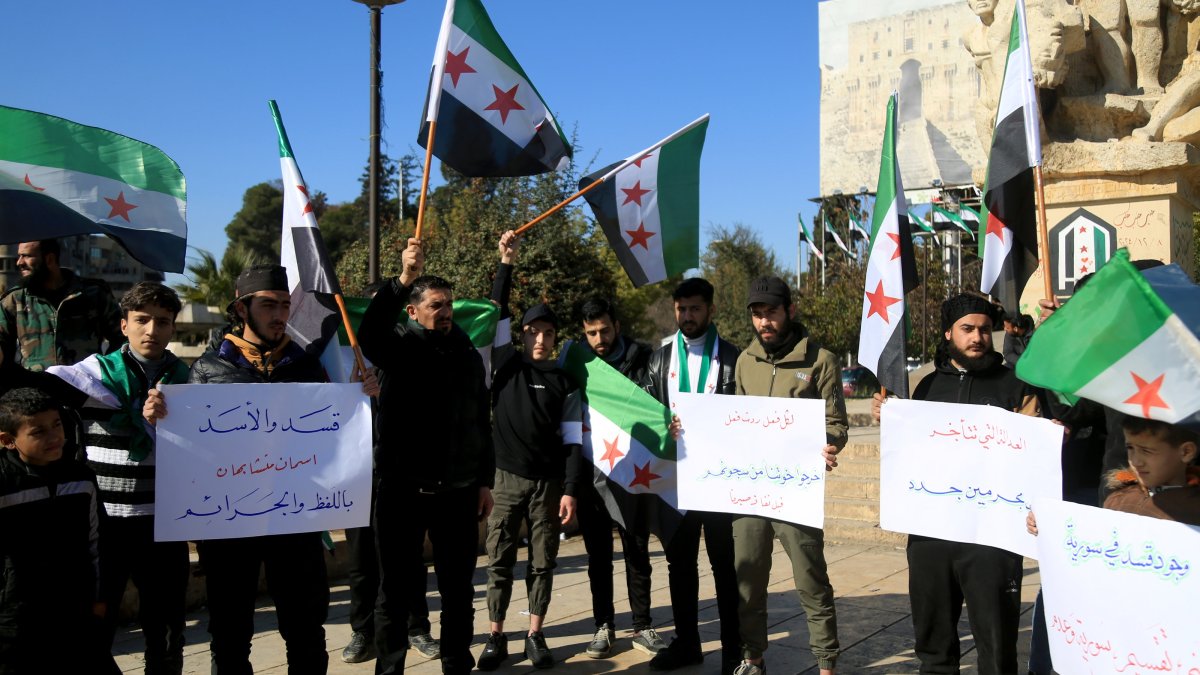 People hold banners protesting the PKK/YPG terrorists in Aleppo, Feb. 14, 2025. (AA Photo)