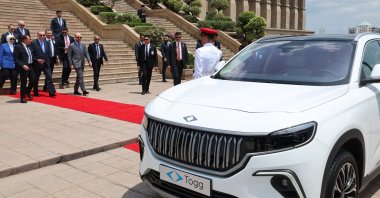 President Recep Tayyip Erdoğan and Malaysian Prime Minister Anwar Ibrahim walk toward a Togg T10X, Putrajaya, Malaysia, Feb. 11, 2025. (AA Photo)