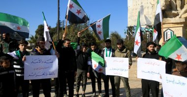 People hold banners protesting the PKK/YPG terrorists in Aleppo, Feb. 14, 2025. (AA Photo)