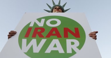 A protestor holds a sign during a demonstration against the NATO summit and U.S. President Donald Trump&#039;s visit, London, U.K., Dec. 3, 2019. (AP Photo)