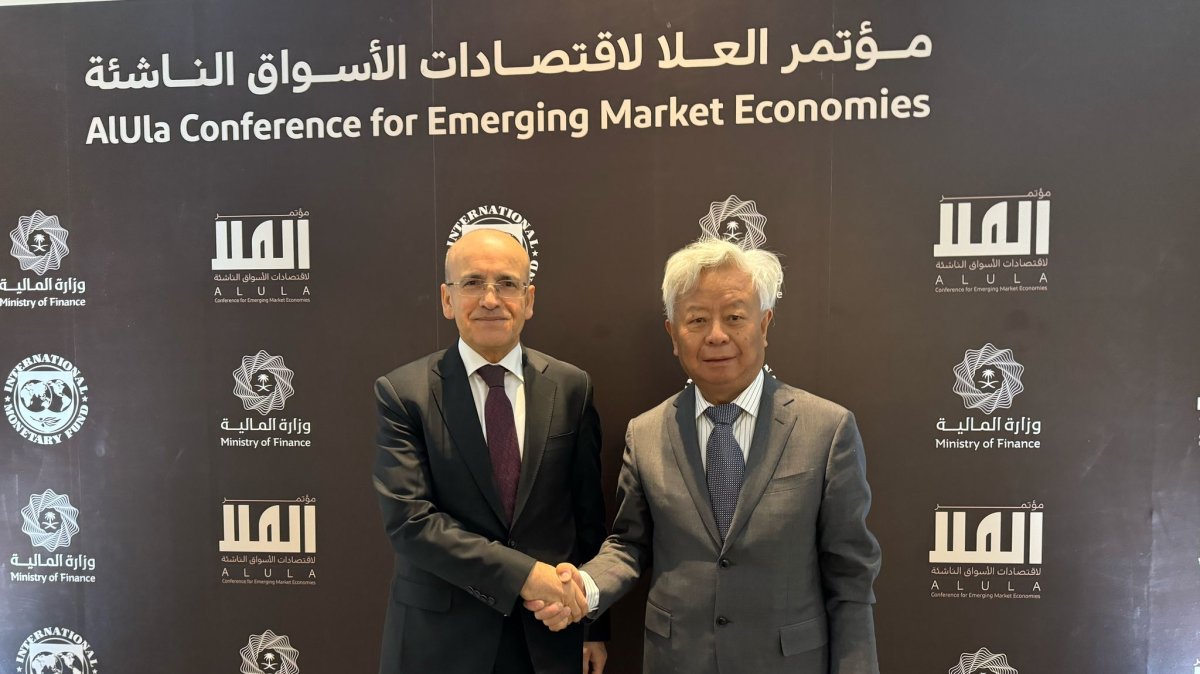 Treasury and Finance Minister Mehmet Şimşek (L) shakes hands with the president of the Asian Infrastructure Investment Bank (AIIB) Jin Liqun, Al-Ula, Saudi Arabia, Feb. 17, 2025. (DHA Photo)