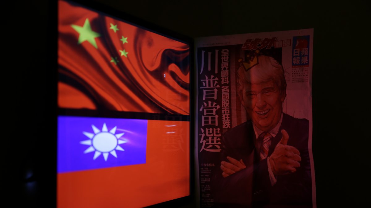 A newspaper headline with the illustration of U.S. President Donald Trump is pictured next to the flag of China and Taiwan in Taipei, Taiwan, Dec.12, 2016. (EPA File Photo)