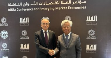 Treasury and Finance Minister Mehmet Şimşek (L) shakes hands with the president of the Asian Infrastructure Investment Bank (AIIB) Jin Liqun, Al-Ula, Saudi Arabia, Feb. 17, 2025. (DHA Photo)