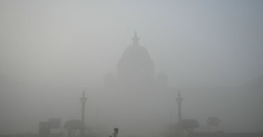 A man walks past the Ministry of Defense building amid dense fog during a cold winter morning in New Delhi, India, Feb. 1, 2025. (AFP Photo)