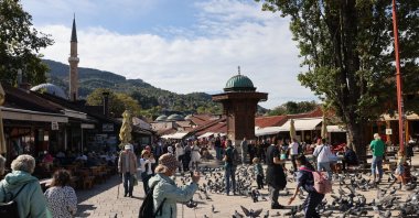 Tourists and visitors walk between pigeons and the Sebilj fountain in the old town, Sarajevo, Bosnia-Herzegovina, Oct. 11, 2024. (Reuters Photo)