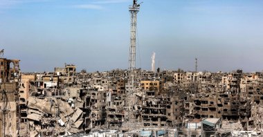 A man fixes a Palestinian flag atop the antenna of a destroyed building that was a clinic for the United Nations Relief and Works Agency for Palestine Refugees (UNRWA) at the Jabalia camp in the northern Gaza Strip, Jan. 19, 2025. (AFP Photo)