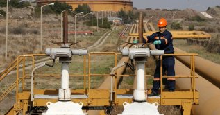 A worker checks the valve gears of pipes linked to oil tanks at the Mediterranean port of Ceyhan, some 70 km(43.5 miles) from Adana province, southern Türkiye, Feb. 19, 2014. (Reuters Photo)