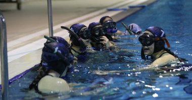 The Turkish champion Çanakkale Onsekiz Mart University (ÇOMÜ) Sports Club athletes pose for a photo in a swimming pool, Çanakkale, Türkiye, Feb. 18, 2025. (AA Photo)