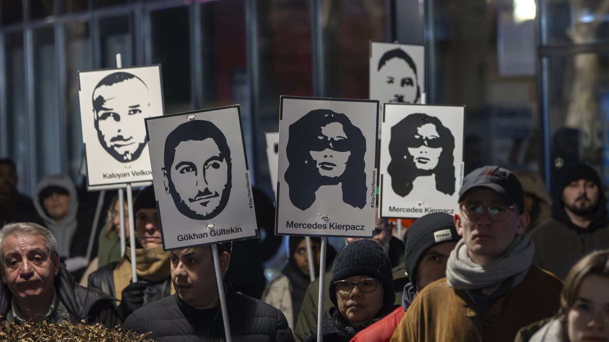 Mourners hold signs with portraits and names of the victims to mark the anniversary of the nine people killed in a shooting by a right-wing extremist on Feb. 19, 2020, during a commemoration at one of the crime scenes, Kesselstadt district, Hanau, Germany, Feb. 19, 2025. (EPA Photo)