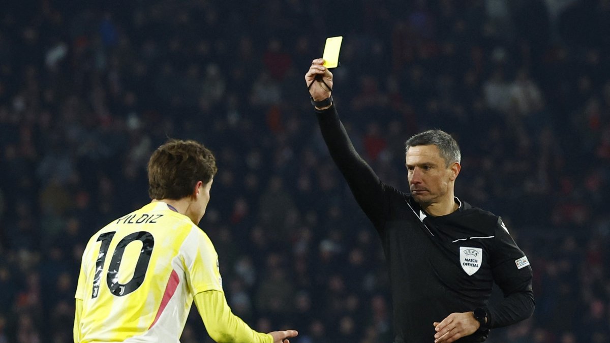 Referee Slavko Vincic (R) shows the yellow card to Juventus&#039; Kenan Yildiz during the Champions League knockout phase playoff second leg match against PSV Eindhoven, Eindhoven, Netherlands, Feb. 19, 2025. (Reuters Photo)