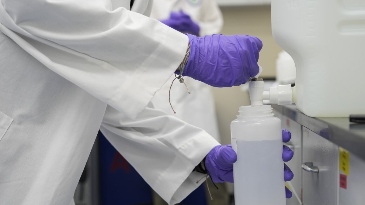 Logan Feeney pours a PFAS water sample into a container for research at a U.S. Environmental Protection Agency lab in Cincinnati, Wednesday, April 10, 2024. (AP File Photo)