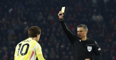 Referee Slavko Vincic (R) shows the yellow card to Juventus&#039; Kenan Yildiz during the Champions League knockout phase playoff second leg match against PSV Eindhoven, Eindhoven, Netherlands, Feb. 19, 2025. (Reuters Photo)