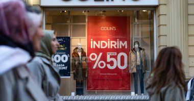 A 50% sale discount sign is displayed in a shop window as people stroll a busy shopping street in Istanbul, Türkiye, Jan. 7, 2025. (Reuters Photo)
