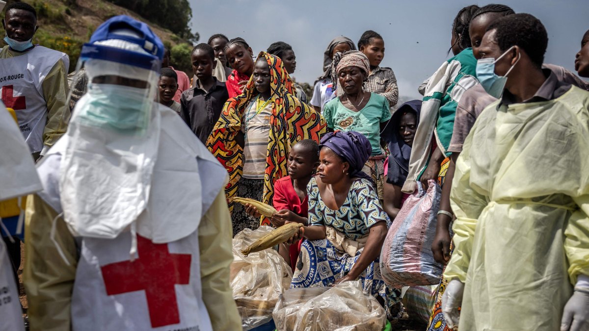 Women sell maize as members of the Congolese Red Cross arrive to bury M23 rebels victims at the Musigiko cemetery, Bukavu, DRC, Feb. 20, 2025. (AFP Photo)