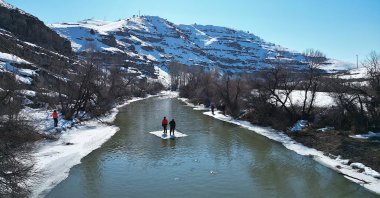 The fishermen cross the river via makeshift ice rafts, in Bayraktar village, Bayburt, northeastern Türkiye, Feb. 21, 2025. (AA Photo)