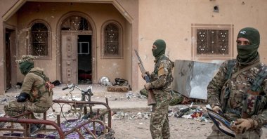 YPG/PKK terrorists are seen in front of a building, Baghouz, Syria, March 24, 2019. (Getty Images Photo)