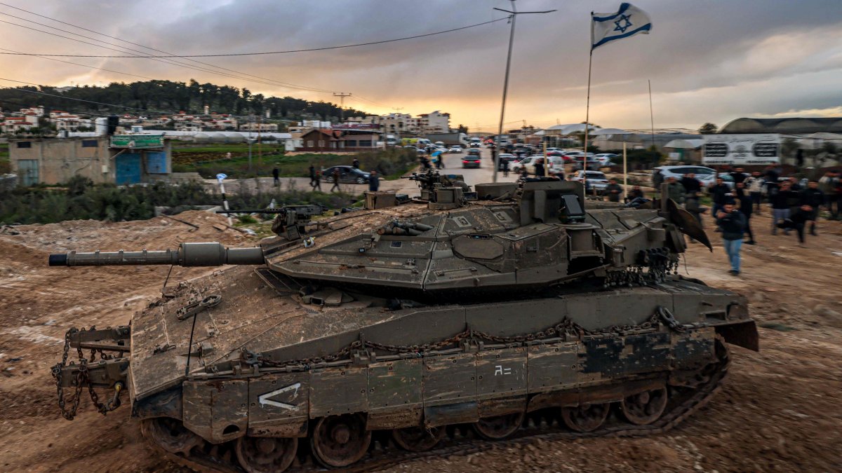 People look on as Israeli tanks enter the Jenin refugee camp in the occupied West Bank, Palestine, Feb. 23, 2025. (AFP Photo)