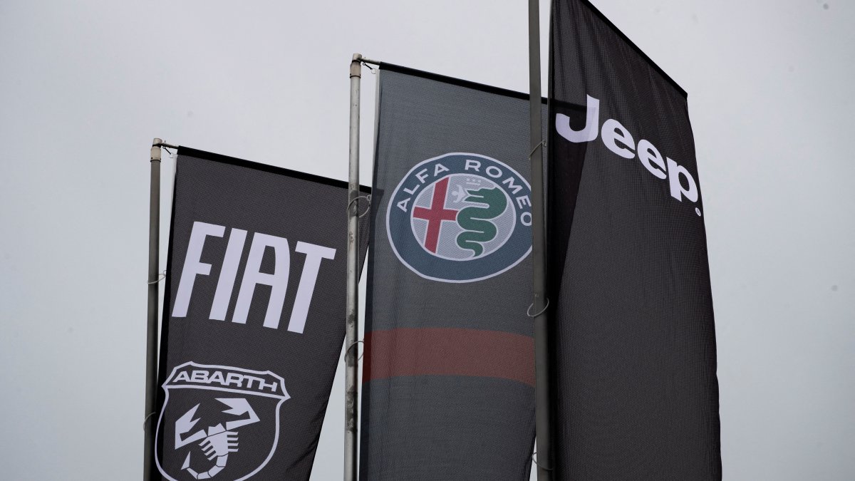 Banners showing logos of Fiat, Jeep, Abarth and Alfa Romeo are hung outside a car dealership in Milan, Italy, Nov. 21, 2024. (Reuters Photo)