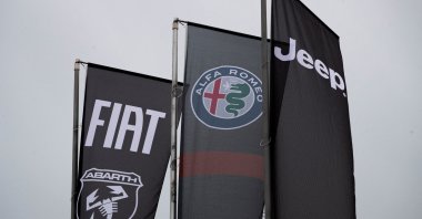Banners showing logos of Fiat, Jeep, Abarth and Alfa Romeo are hung outside a car dealership in Milan, Italy, Nov. 21, 2024. (Reuters Photo)