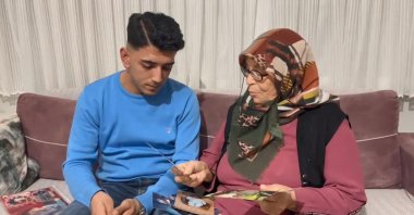 Sefa Ünal, sitting next to his adoptive mother Döndü Ünal, learns he is adopted after returning from military service, Bursa, Türkiye, Feb. 23, 2025. (DHA Photo)