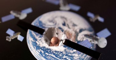 A satellite model is placed on a picture of Earth in this illustration taken Nov. 25, 2024. (Reuters Photo)