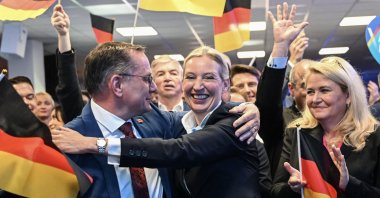 Co-leaders of Germany&#039;s far-right Alternative for Germany (AfD) party Alice Weidel (C) and Tino Chrupalla (L) hug during the electoral evening, Berlin, Germany, Feb. 23, 2025. (AFP Photo)