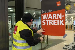 A Verdi representative hangs up a poster with the words &quot;Warning strike&quot; in a terminal at Hamburg Airport, Hamburg, Germany, Feb. 12, 2025. (AP Photo)