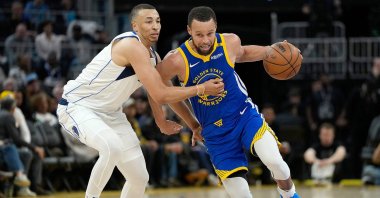 Golden State Warriors' Stephen Curry (R) drives the ball past Dallas Mavericks' Dante Exum during the second half at Chase Center, San Francisco, California, U.S., Feb. 23, 2025. (AFP Photo)