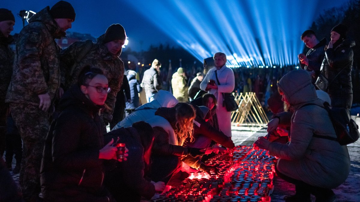 Citizens and families of Ukrainian soldiers, who were killed during the Russia-Ukraine war, take part in a ceremony to honor the memory of fallen soldiers on the eve of the third anniversary of the Russian-Ukrainian war, where "rays of remembrance" are lit into the sky above the Lychakiv Cemetery, Lviv, Ukraine, Feb. 23, 2025. (AA Photo)