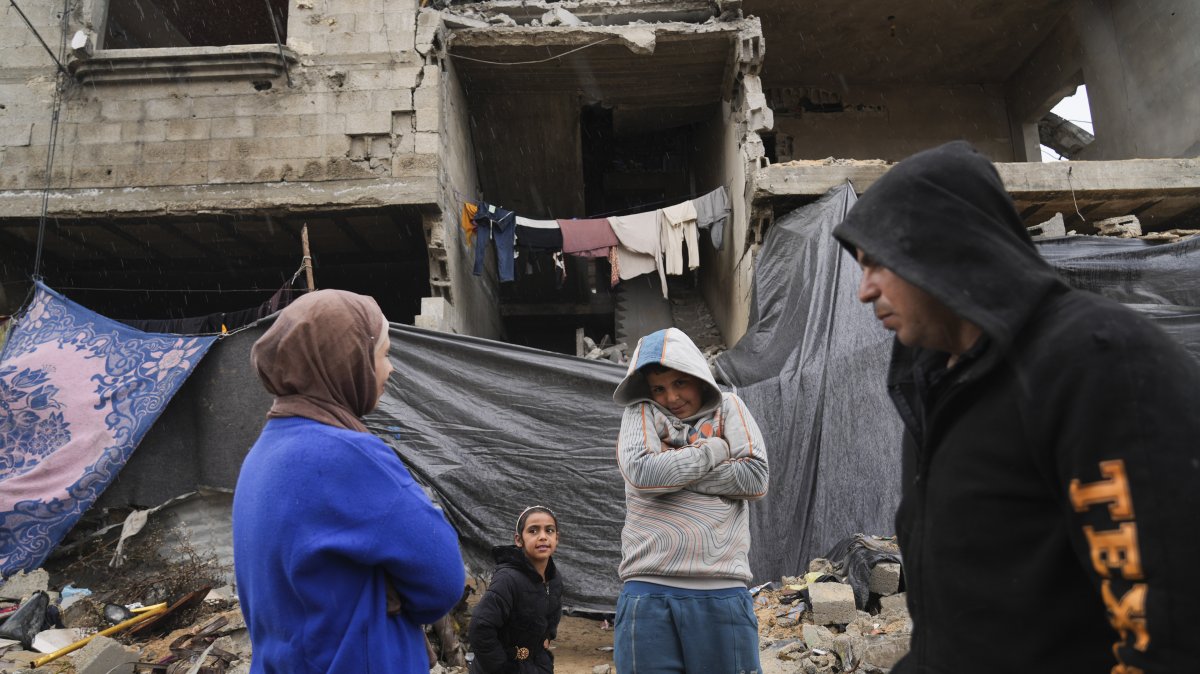 Members of the Tambora family stand outside their four-story home, which was struck by Israeli airstrikes, Beit Lahiya, Gaza Strip, Palestine, Feb. 21, 2025. (AP Photo)