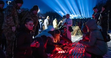 Citizens and families of Ukrainian soldiers, who were killed during the Russia-Ukraine war, take part in a ceremony to honor the memory of fallen soldiers on the eve of the third anniversary of the Russian-Ukrainian war, where "rays of remembrance" are lit into the sky above the Lychakiv Cemetery, Lviv, Ukraine, Feb. 23, 2025. (AA Photo)