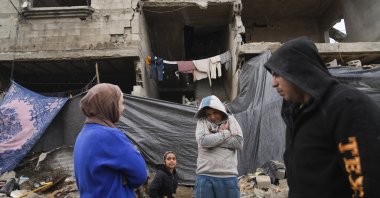 Members of the Tambora family stand outside their four-story home, which was struck by Israeli airstrikes, Beit Lahiya, Gaza Strip, Palestine, Feb. 21, 2025. (AP Photo)