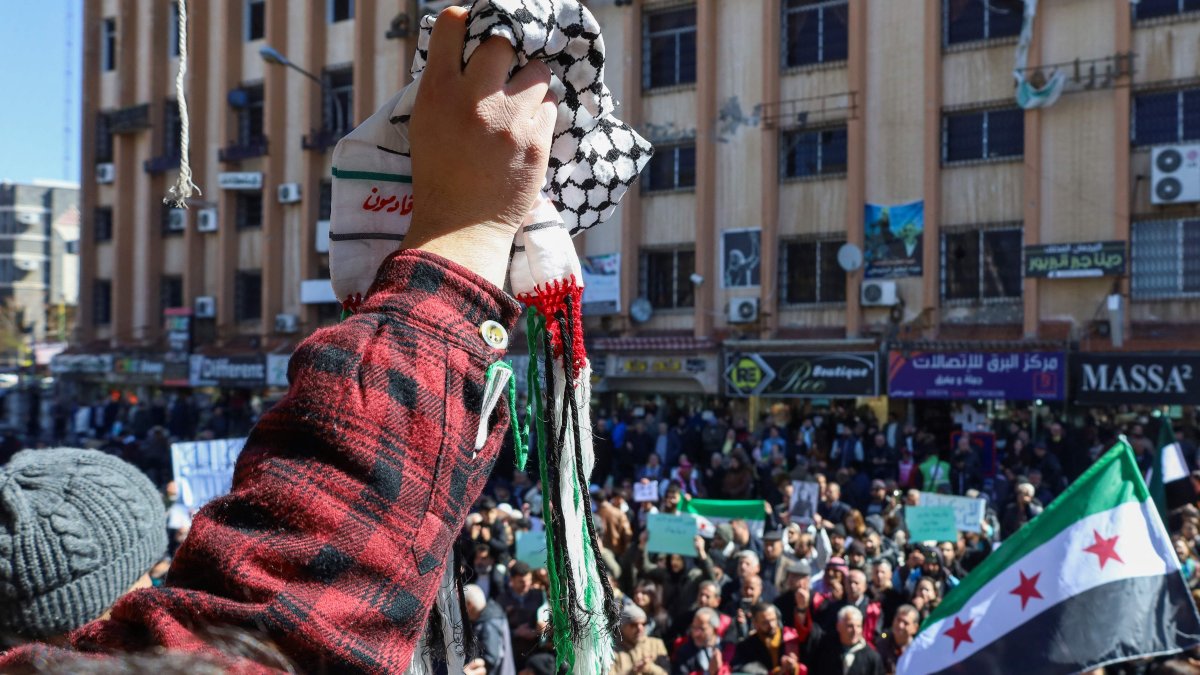 A protester lifts a traditional Palestinian keffiyeh scarf as Syrians demonstrate Israeli statements on occupying southern parts of the country, in Suwayda, southern Syria, Feb. 25, 2025. (AFP Photo)