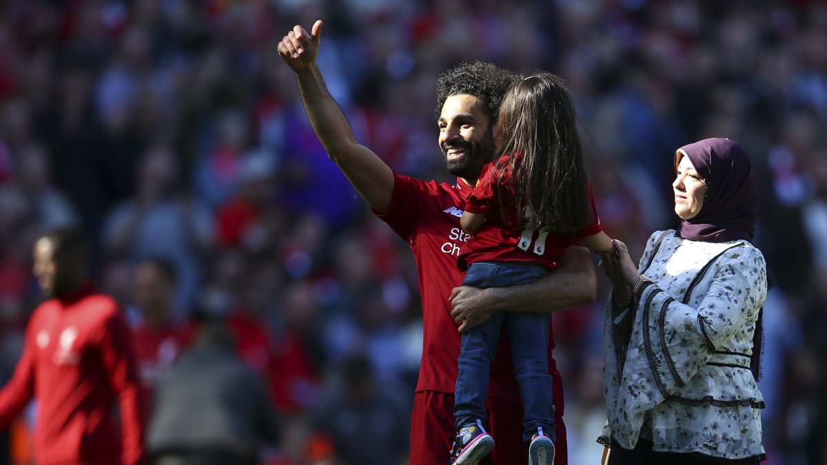 Liverpool&#039;s Mohamed Salah (L), accompanied by his wife Magi greets supporters while holding his daughter Makkah at the end of the English Premier League match against Wolves at the Anfield stadium, Liverpool, U.K., May 12, 2019. (AP Photo)