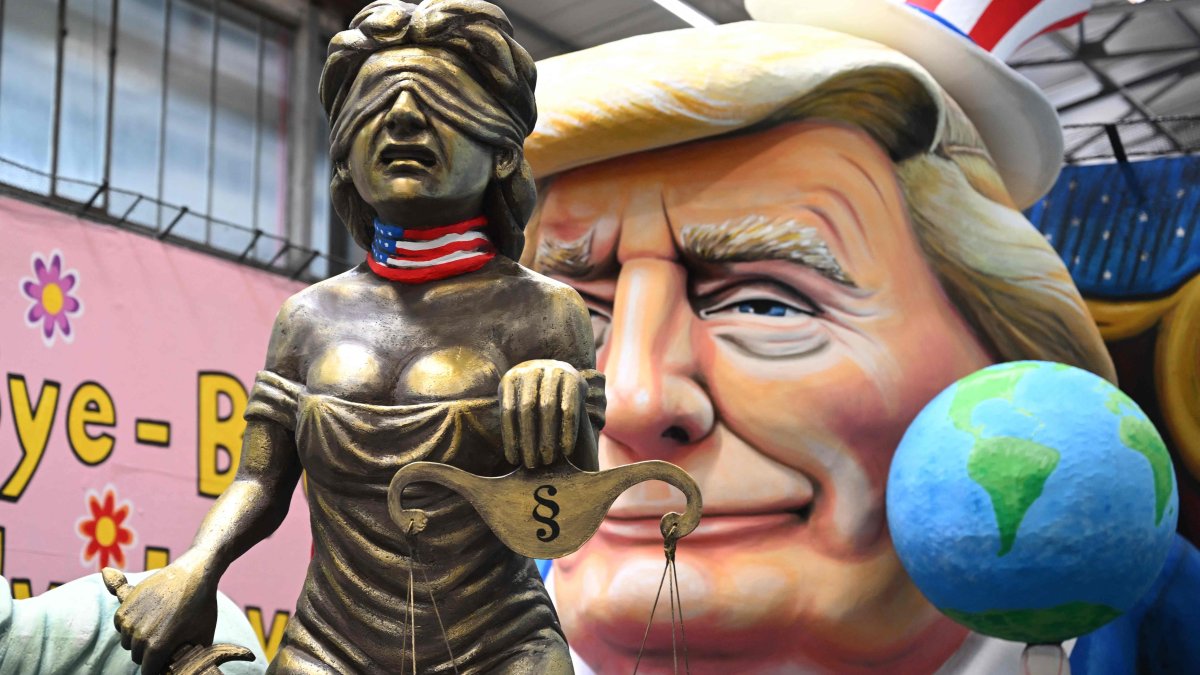 A carnival float showing Donald Trump keeping the Statue of Liberty and Justice on a leash as he is showing a finger to the world, in Cologne, Germany, Feb. 25, 2025. (AFP Photo)