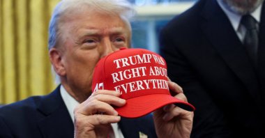 U.S. President Donald Trump holds a hat after signing an executive order in the Oval Office, at the White House, Washington, U.S. Feb. 25, 2025. (Reuters Photo)
