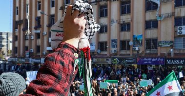 A protester lifts a traditional Palestinian keffiyeh scarf as Syrians demonstrate Israeli statements on occupying southern parts of the country, in Suwayda, southern Syria, Feb. 25, 2025. (AFP Photo)