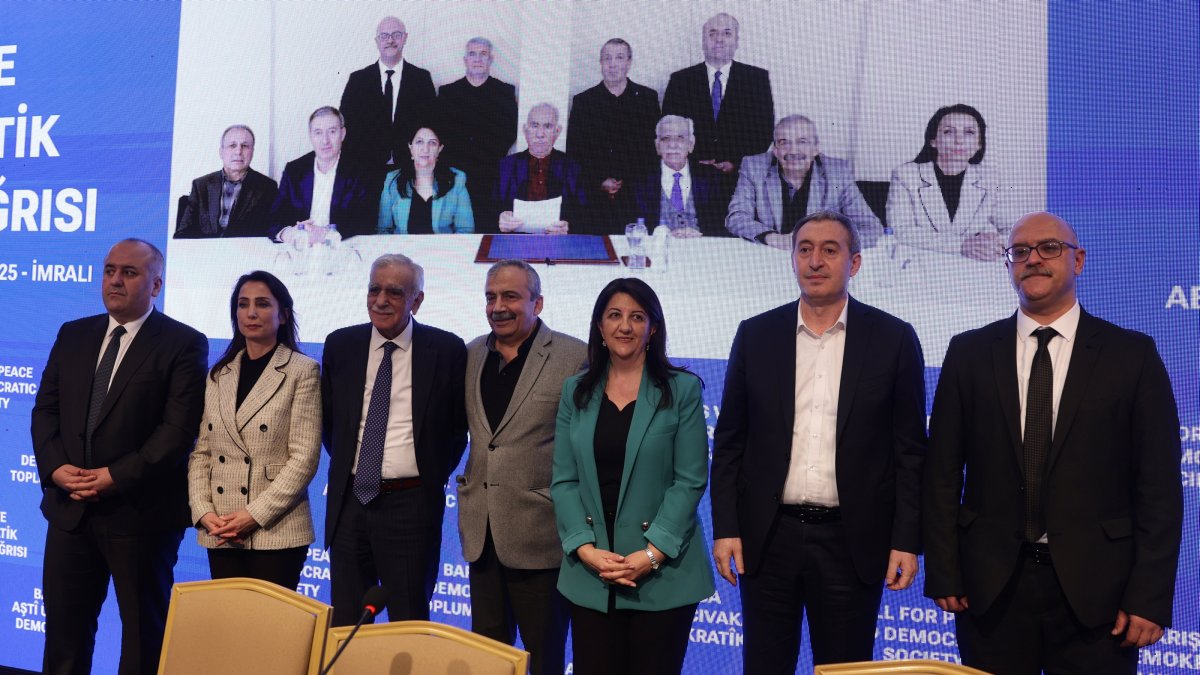Delegation members of the DEM Party pose at a news conference held after a visit with jailed PKK terrorist leader Abdullah Öcalan (seen in the on-screen photo, center), Istanbul, Türkiye, Feb. 27, 2025. (EPA Photo)