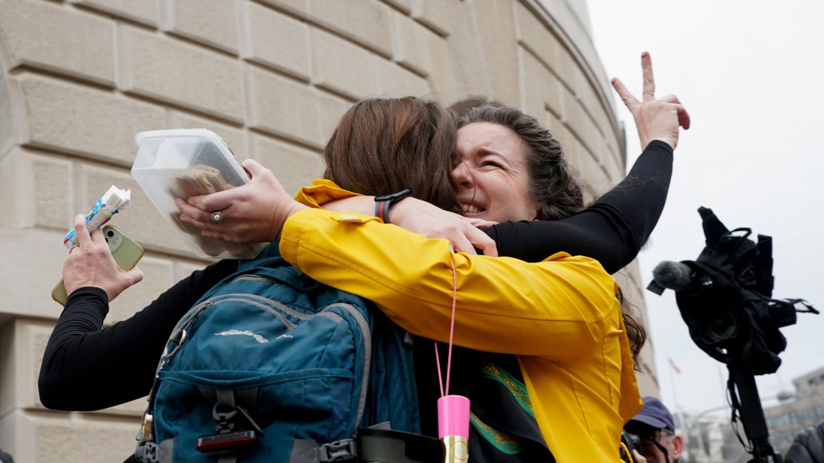Terminated U.S. Agency for International Development (USAID) employee Caitlin Harwood gestures as she hugs her cousin Samantha Kent after laid-off USAID workers cleared out their desks and collected personal belongings, during a sendoff in Washington, D.C., U.S., Feb. 27, 2025. (Reuters Photo)