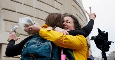 Terminated U.S. Agency for International Development (USAID) employee Caitlin Harwood gestures as she hugs her cousin Samantha Kent after laid-off USAID workers cleared out their desks and collected personal belongings, during a sendoff in Washington, D.C., U.S., Feb. 27, 2025. (Reuters Photo)