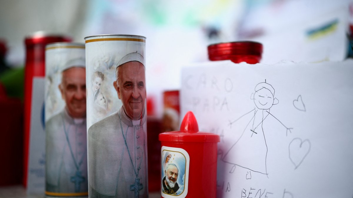 Candles with an image of Pope Francis and other tributes are left near the statue of late Pope John Paul II outside Gemelli Hospital where Pope Francis has been admitted for treatment, Rome, Italy, Feb. 27, 2025. (Reuters Photo)