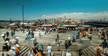 People walk in Eminönü, famous for fish and bread boats, Istanbul, Türkiye, June 20, 2021. (Shutterstock Photo)