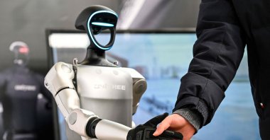 A man shakes hands with a humanoid robot from Unitree Robotics during the Global Developer Conference, organised by the Shanghai AI Industry Association, Shanghai, China, Feb. 21, 2025. (AFP Photo)