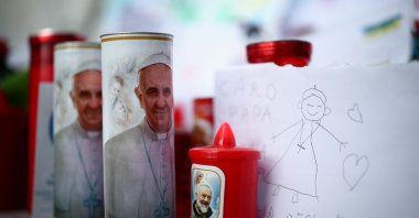 Candles with an image of Pope Francis and other tributes are left near the statue of late Pope John Paul II outside Gemelli Hospital where Pope Francis has been admitted for treatment, Rome, Italy, Feb. 27, 2025. (Reuters Photo)