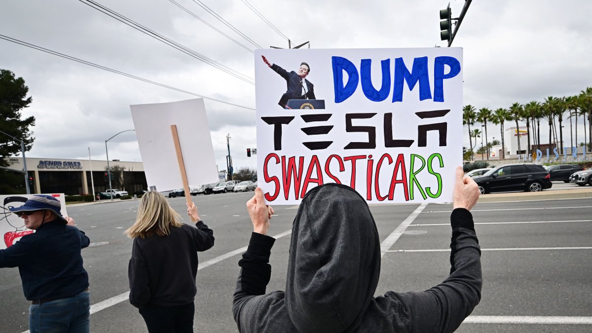 People participate in a &quot;TeslaTakedown&quot; protest against Elon Musk outside of a Tesla dealership in Irvine, California, U.S., March 1, 2025. (AFP Photo)